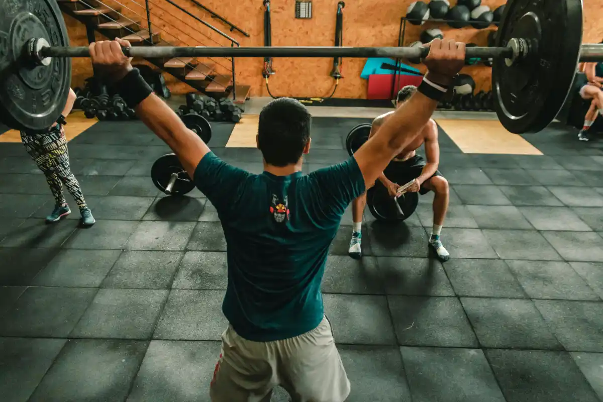 Athlete performing a power clean with a loaded barbell, capturing explosive movement and full-body strength development.