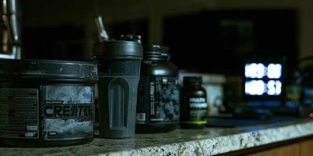 Supplements like creatine and protein powder lined up beside a late-night clock